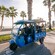 A group of Guests riding a Tuk Tuk along a palm tree lined road near the Málaga coastline